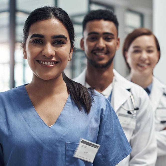 Three smiling healthcare professionals in a modern medical setting.